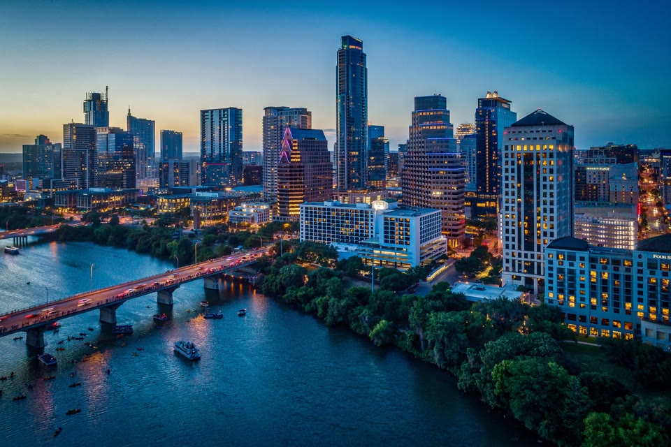 Austin, Texas skyline at dusk with Congress Avenue Bridge lit up over Lady Bird Lake