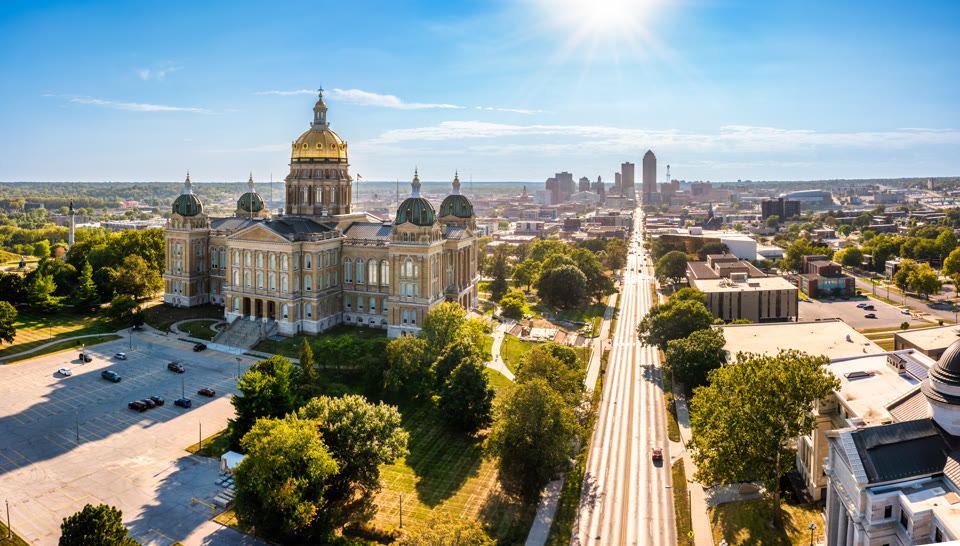 The Iowa State Capitol's golden dome with the Des Moines skyline behind it