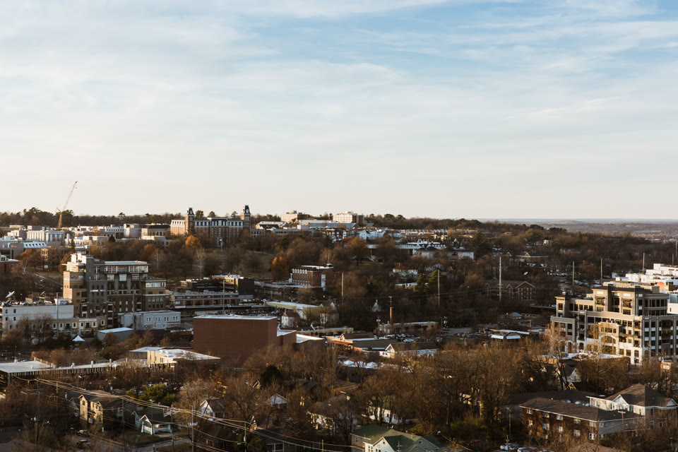 The University of Arkansas' Old Main above downtown Fayetteville at golden hour