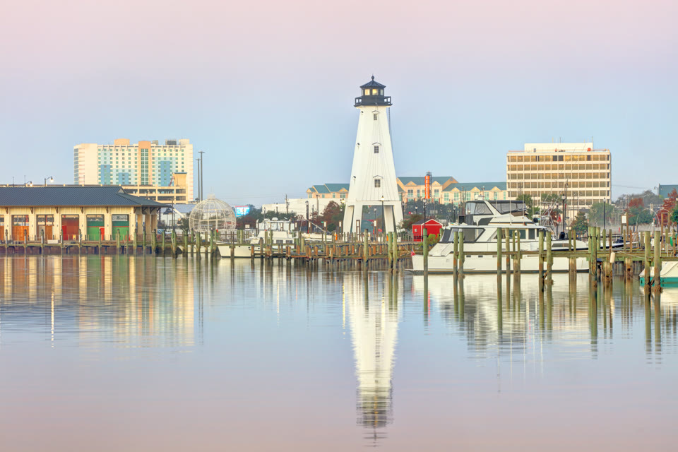 The Gulfport Harbor Light at the marina, with hotel towers behind it, in Gulfport, Mississippi