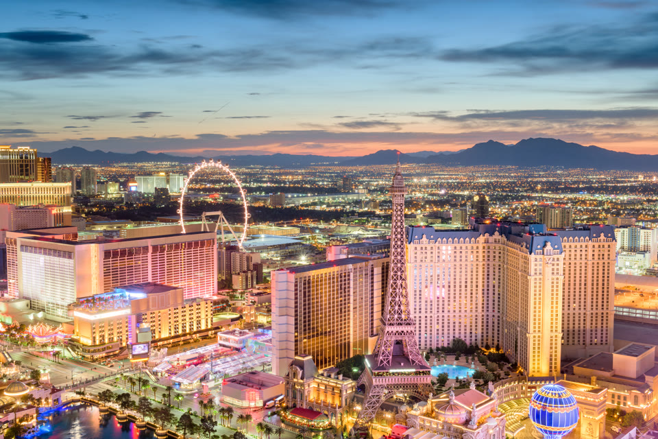 The Las Vegas Strip at dusk, with the Eiffel Tower replica and the High Roller observation wheel