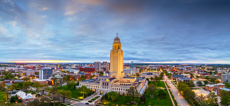 The Nebraska State Capitol tower rising above downtown Lincoln at dusk