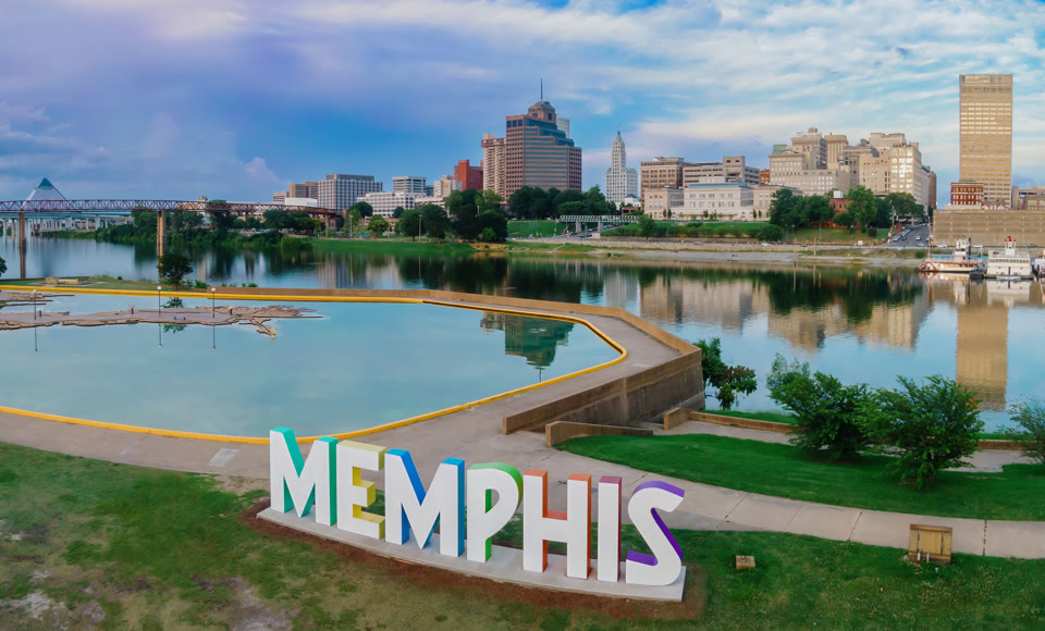 A "MEMPHIS" sign at Tom Lee Park with the Hernando de Soto Bridge and downtown Memphis, Tennessee skyline behind it
