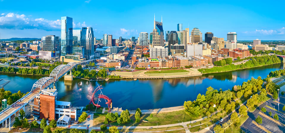 Aerial panorama of the Nashville skyline with the pedestrian bridge and riverfront