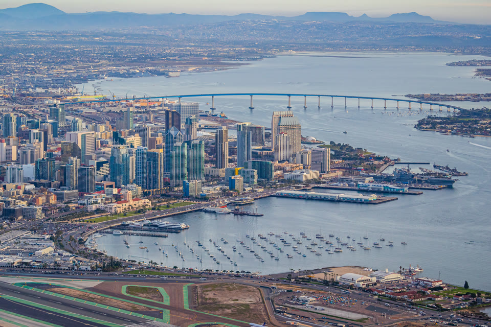 The Coronado Bridge and downtown San Diego, California skyline with Navy ships in the harbor