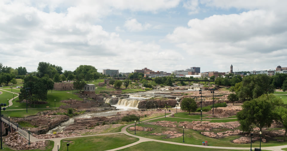 Falls Park on the Big Sioux River with the downtown Sioux Falls, South Dakota skyline behind it