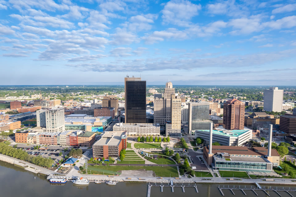 Downtown Toledo, Ohio's riverfront park and skyline along the Maumee River, with Fifth Third Field ballpark visible